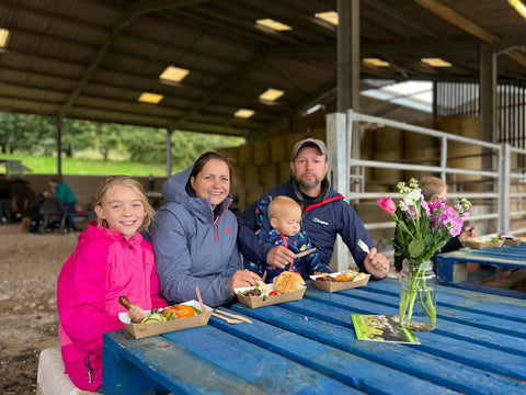 A family enjoying the Farm2Fork BBQ in the farm barn